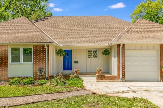 single story home featuring brick siding, a shingled roof, board and batten siding, and a garage