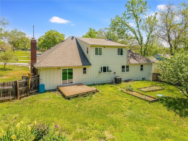 back of property featuring a deck, a fenced backyard, a vegetable garden, central AC unit, and a shingled roof