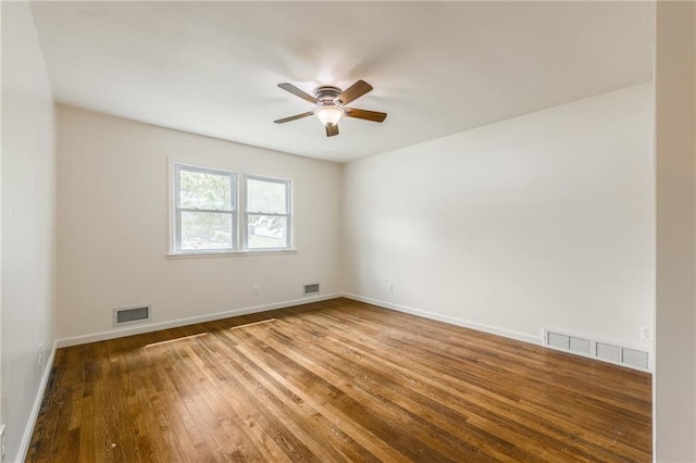 unfurnished room featuring baseboards, ceiling fan, hardwood / wood-style floors, and visible vents