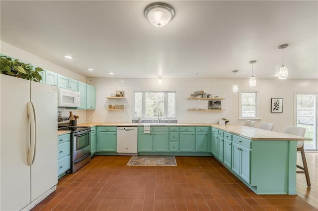 kitchen featuring open shelves, white appliances, light countertops, a peninsula, and a kitchen bar