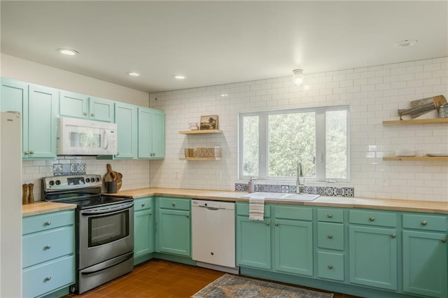 kitchen with white appliances, open shelves, decorative backsplash, and a sink