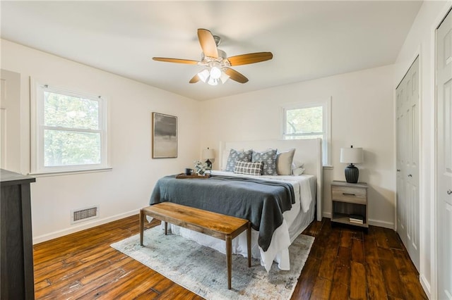 bedroom with baseboards, ceiling fan, dark wood finished floors, and visible vents