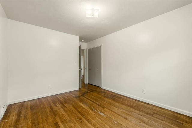 empty room featuring baseboards and wood finished floors