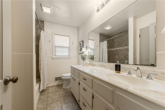 full bathroom featuring toilet, visible vents, wainscoting, and vanity