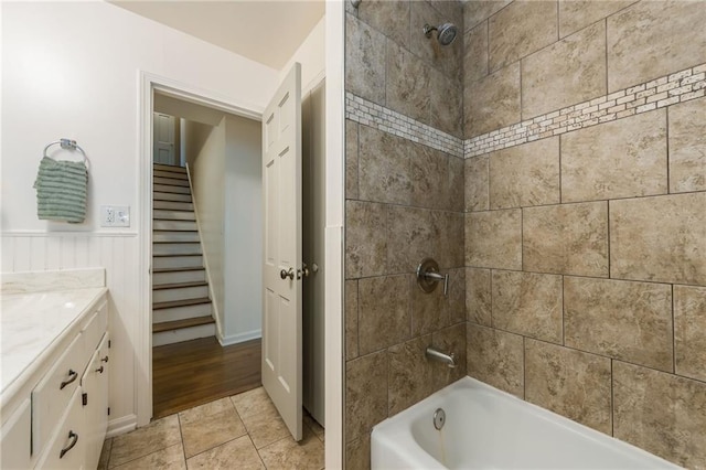 bathroom with vanity, wainscoting, and shower / washtub combination