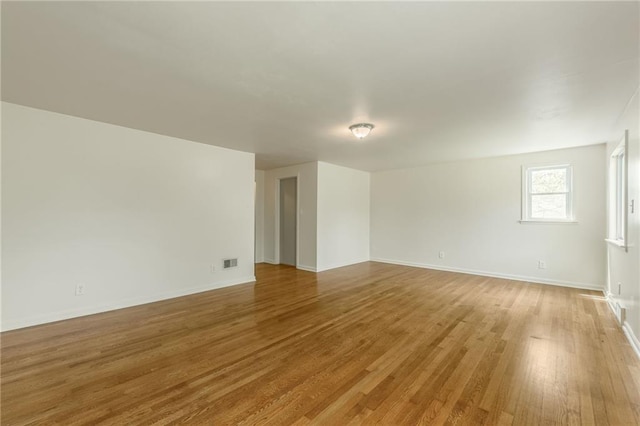 unfurnished living room featuring baseboards, light wood-style flooring, and visible vents