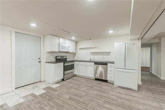 kitchen with dark countertops, open shelves, white cabinets, stainless steel appliances, and recessed lighting