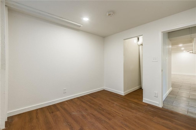 spare room featuring recessed lighting, baseboards, and wood finished floors