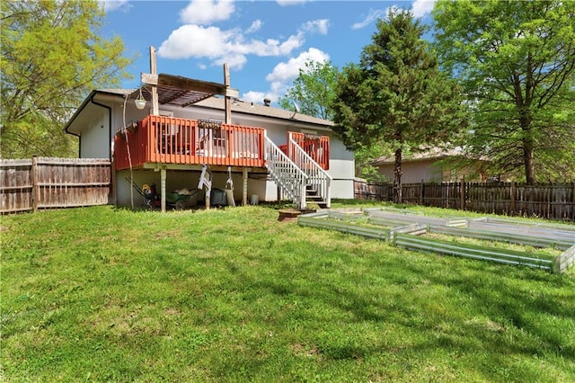 rear view of property with a lawn, a fenced backyard, stairway, and a deck