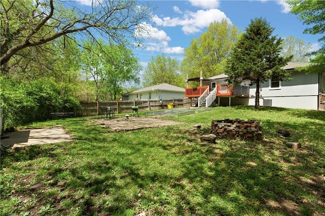 view of yard with a patio area, a wooden deck, stairway, and fence