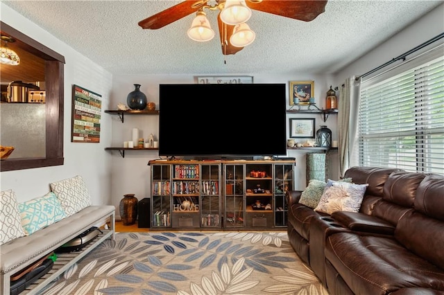 carpeted living area featuring ceiling fan and a textured ceiling