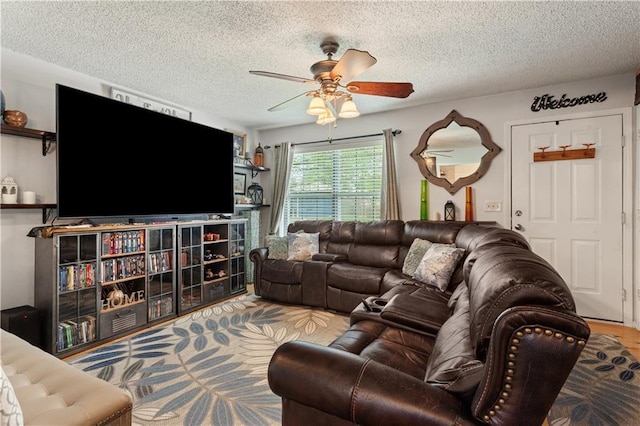 living area featuring a ceiling fan and a textured ceiling