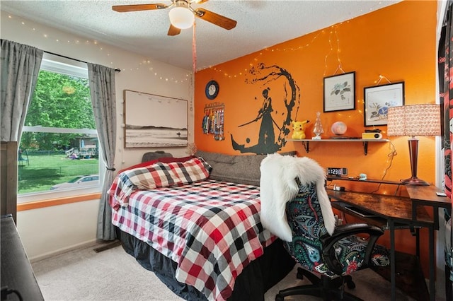 bedroom featuring carpet floors, a ceiling fan, a textured ceiling, and baseboards
