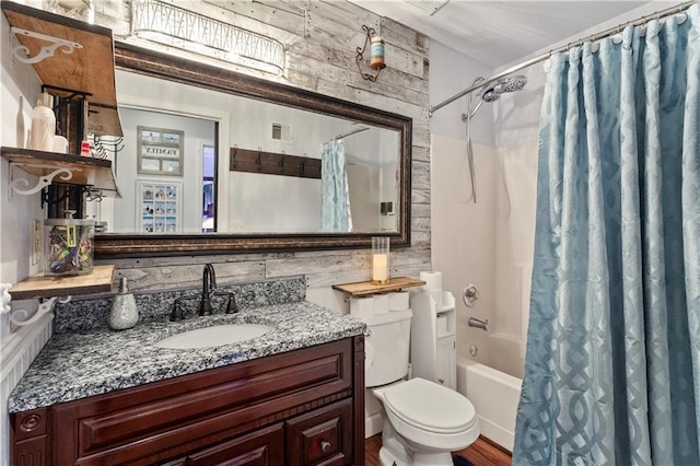 bathroom with visible vents, shower / bath combination with curtain, wood finished floors, vanity, and toilet