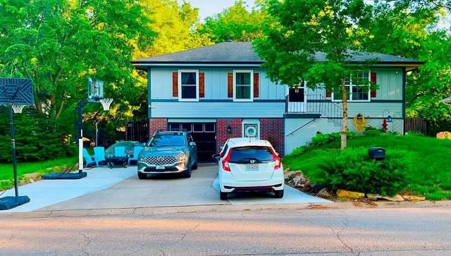 view of front facade featuring board and batten siding, an attached garage, driveway, and brick siding