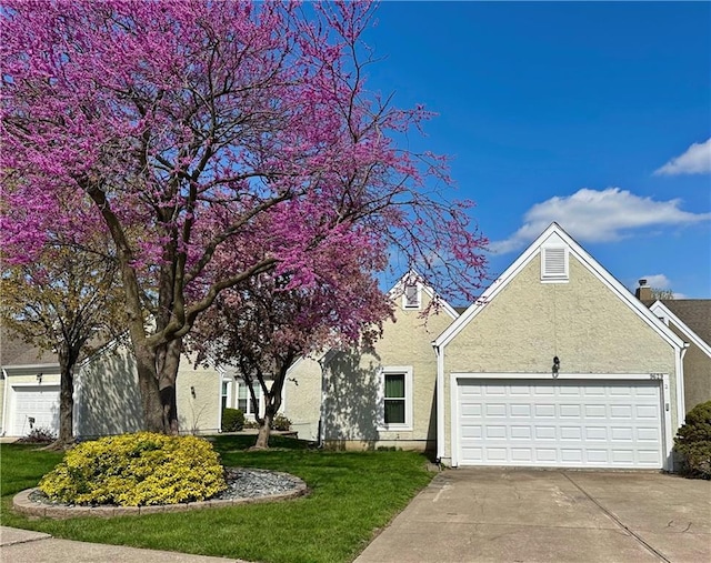 9629 N Locust Dr, Kansas City, MO 64155 - view of front of house featuring an attached garage, stucco siding, a front yard, and concrete driveway