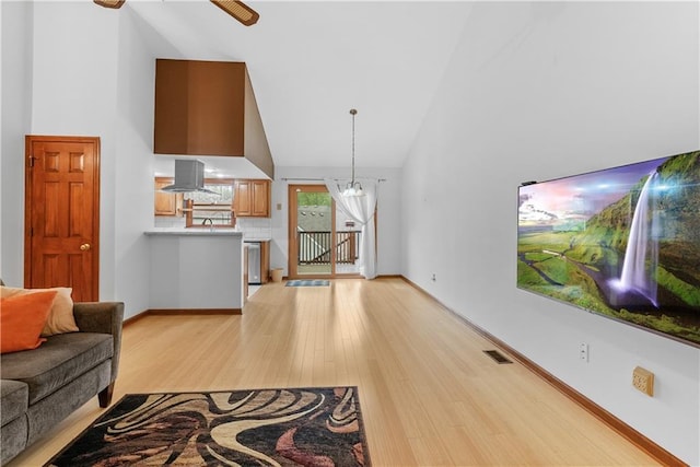 9629 N Locust Dr, Kansas City, MO 64155 - living room featuring high vaulted ceiling, baseboards, a ceiling fan, and light wood-style flooring