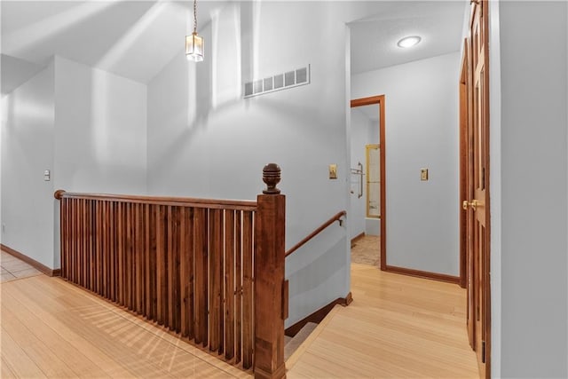 9629 N Locust Dr, Kansas City, MO 64155 - hall with baseboards, visible vents, wood finished floors, and an upstairs landing