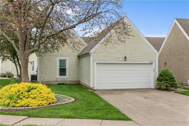 9629 N Locust Dr, Kansas City, MO 64155 - view of front of property featuring driveway, central AC unit, a front lawn, an attached garage, and stucco siding