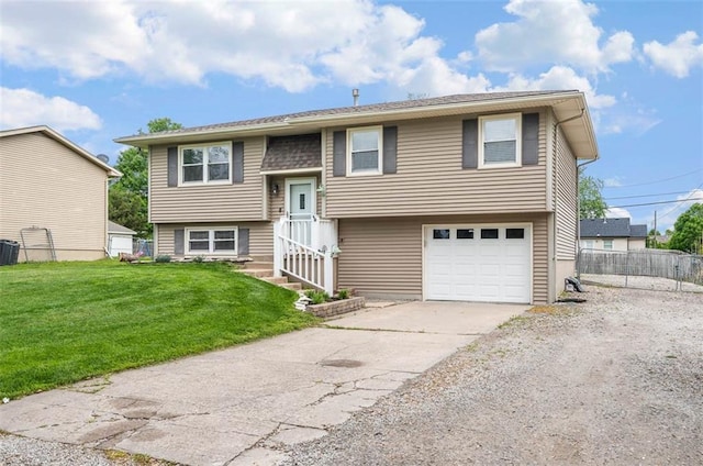 raised ranch with concrete driveway, central AC, and an attached garage