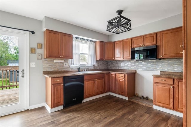kitchen with dishwasher, stainless steel microwave, a sink, and brown cabinetry
