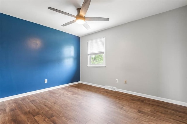 empty room with a ceiling fan, baseboards, and wood finished floors