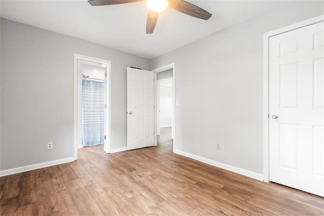 unfurnished bedroom with baseboards, wood finished floors, and a ceiling fan