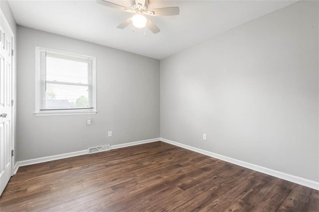 empty room featuring dark wood-style floors and baseboards