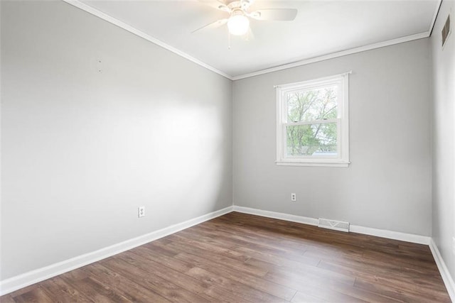 empty room featuring ornamental molding, baseboards, wood finished floors, and ceiling fan