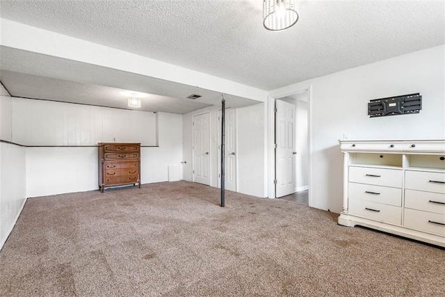 finished below grade area featuring carpet flooring and a textured ceiling