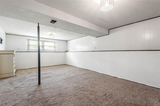 below grade area with a textured ceiling and carpet floors