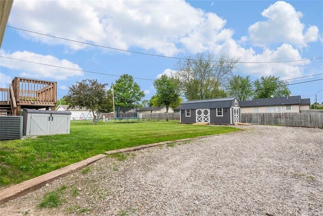 view of yard featuring a shed, a trampoline, and an outdoor structure