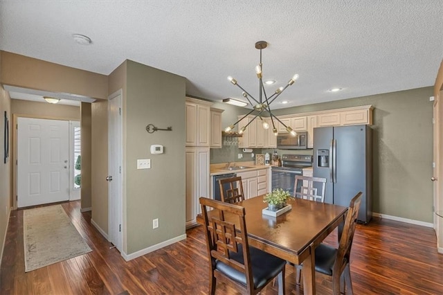 dining space with dark wood-style flooring, a textured ceiling, an inviting chandelier, and baseboards