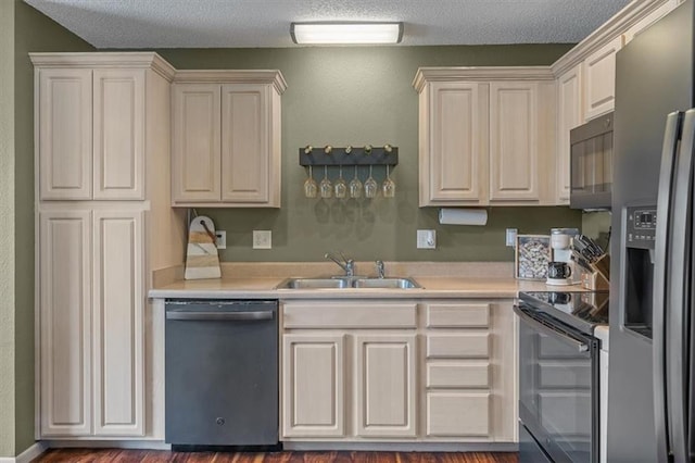 kitchen with a textured ceiling, dishwasher, light countertops, a sink, and stainless steel fridge