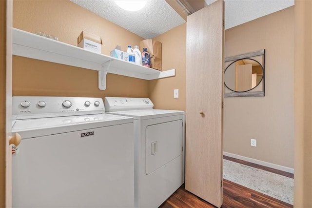 washroom featuring laundry area, dark wood-style flooring, washing machine and dryer, baseboards, and a textured ceiling