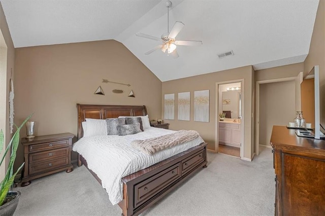 bedroom with ceiling fan, light colored carpet, visible vents, vaulted ceiling, and ensuite bath