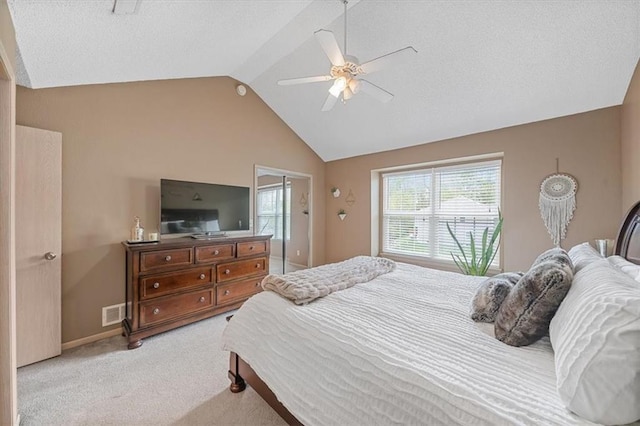 bedroom with visible vents, light carpet, ceiling fan, a textured ceiling, and vaulted ceiling