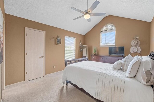 carpeted bedroom featuring a textured ceiling, ceiling fan, vaulted ceiling, and multiple windows