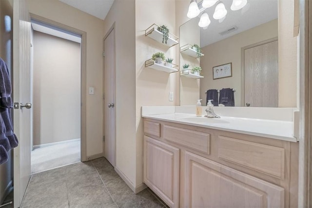 bathroom with a notable chandelier, visible vents, tile patterned flooring, and vanity