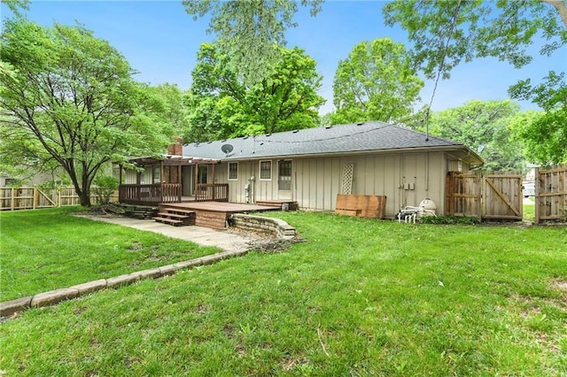 2217 Kingman St, Leavenworth, KS 66048 - back of property with board and batten siding, a wooden deck, a fenced backyard, a gate, and a shingled roof