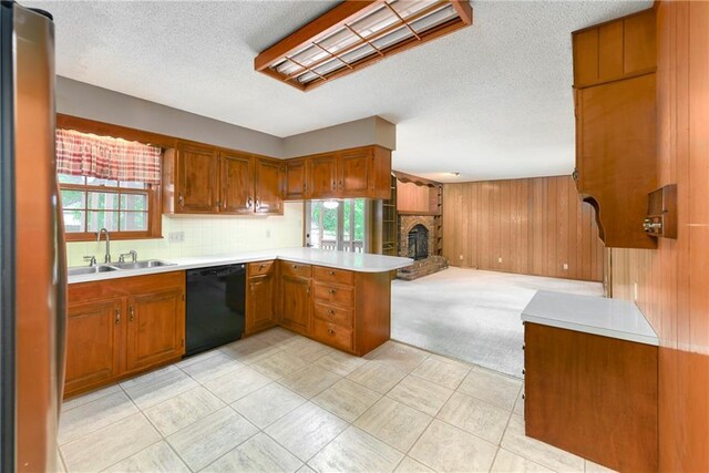2217 Kingman St, Leavenworth, KS 66048 - kitchen with black dishwasher, open floor plan, brown cabinetry, a peninsula, and light countertops