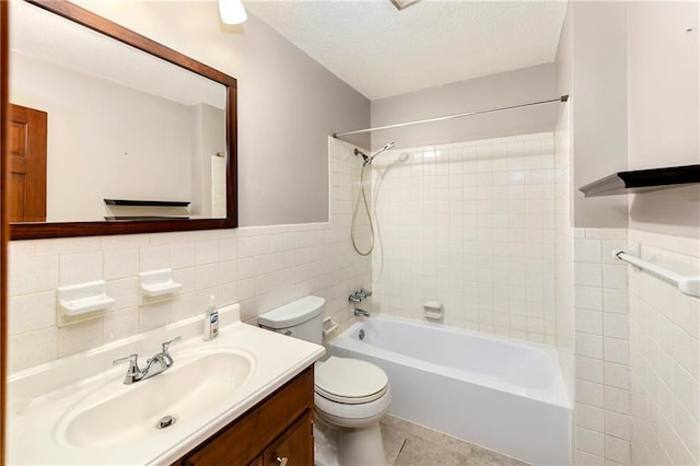 2217 Kingman St, Leavenworth, KS 66048 - bathroom with tile walls, shower / bath combination, vanity, a textured ceiling, and tile patterned flooring