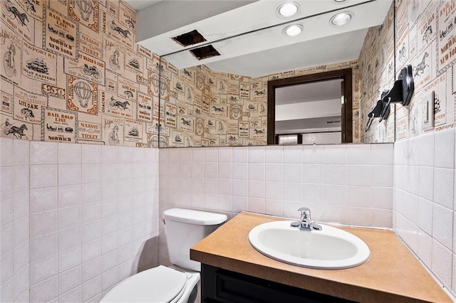 18104 E 24th St S, Independence, MO 64057 - bathroom with toilet, wallpapered walls, vanity, tile walls, and recessed lighting