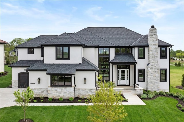 view of front facade featuring a front yard, a chimney, stone siding, and stucco siding