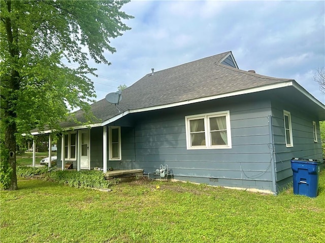 exterior space featuring a lawn, roof with shingles, and crawl space