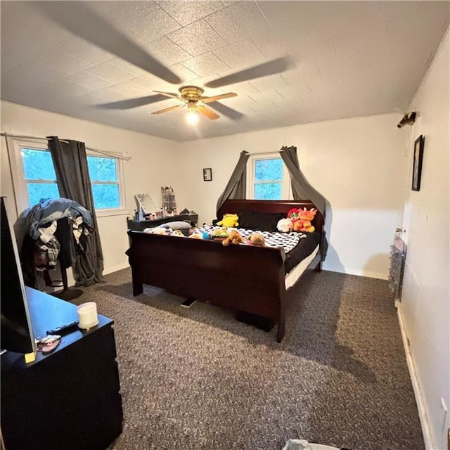 carpeted bedroom featuring baseboards, multiple windows, and ceiling fan