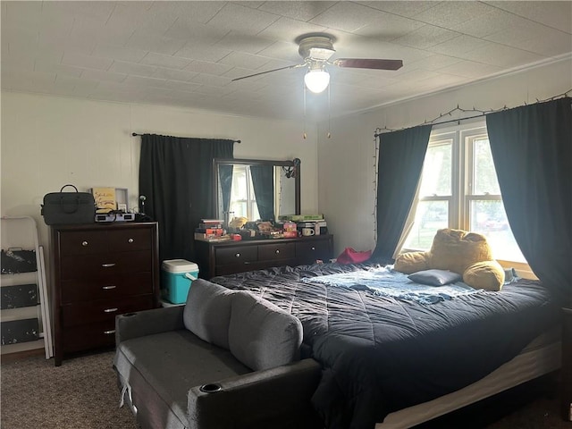 bedroom featuring a ceiling fan, multiple windows, and carpet