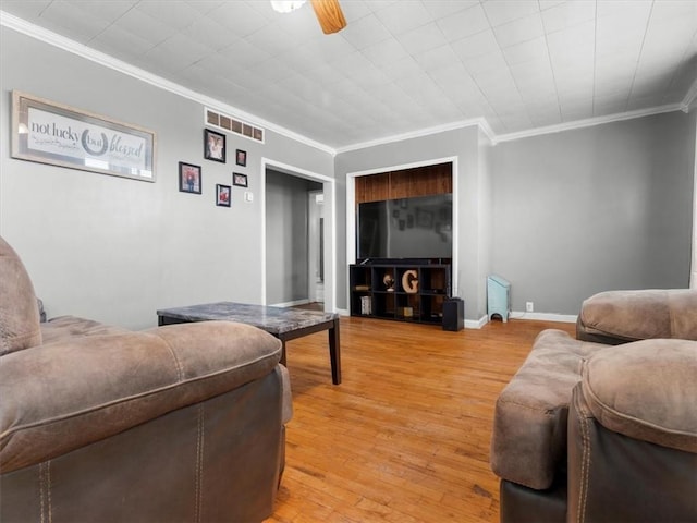 living room with crown molding, light wood finished floors, and ceiling fan