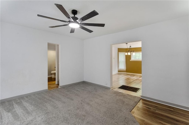 628 S Mulberry St, Ottawa, KS 66067 - spare room with a chandelier, a ceiling fan, baseboards, wood finished floors, and carpet flooring