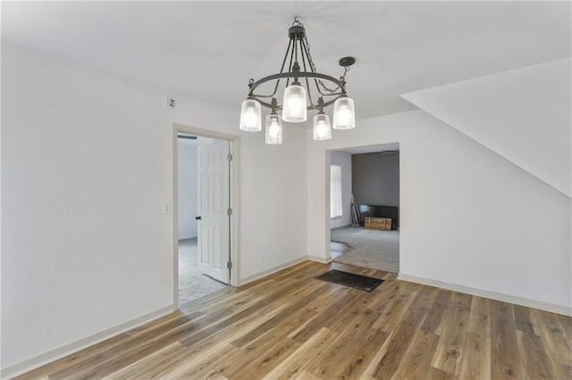628 S Mulberry St, Ottawa, KS 66067 - unfurnished dining area with a chandelier, wood finished floors, and baseboards
